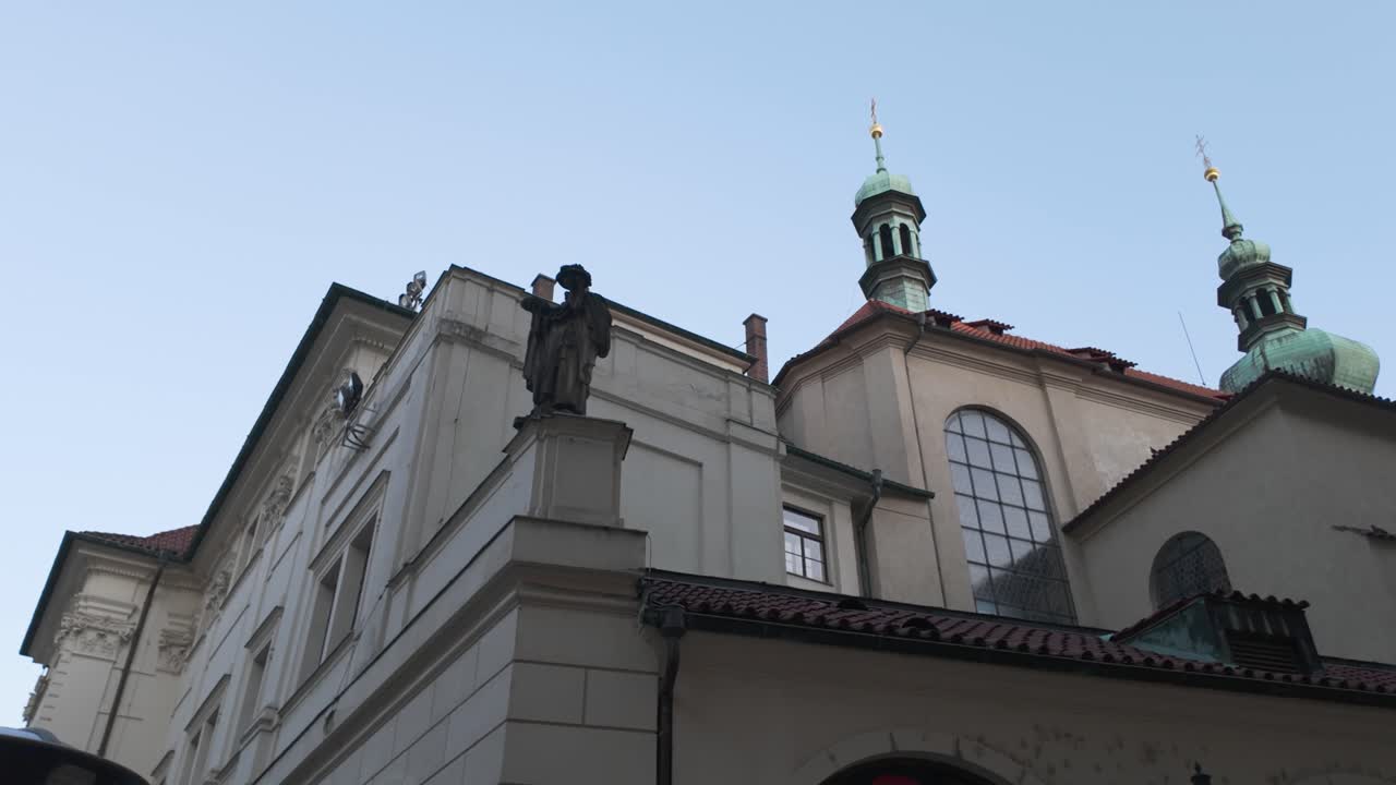 Church of St. Gallen with its iconic twin copper spires standing tall against the clear sky in Prague, Czechia