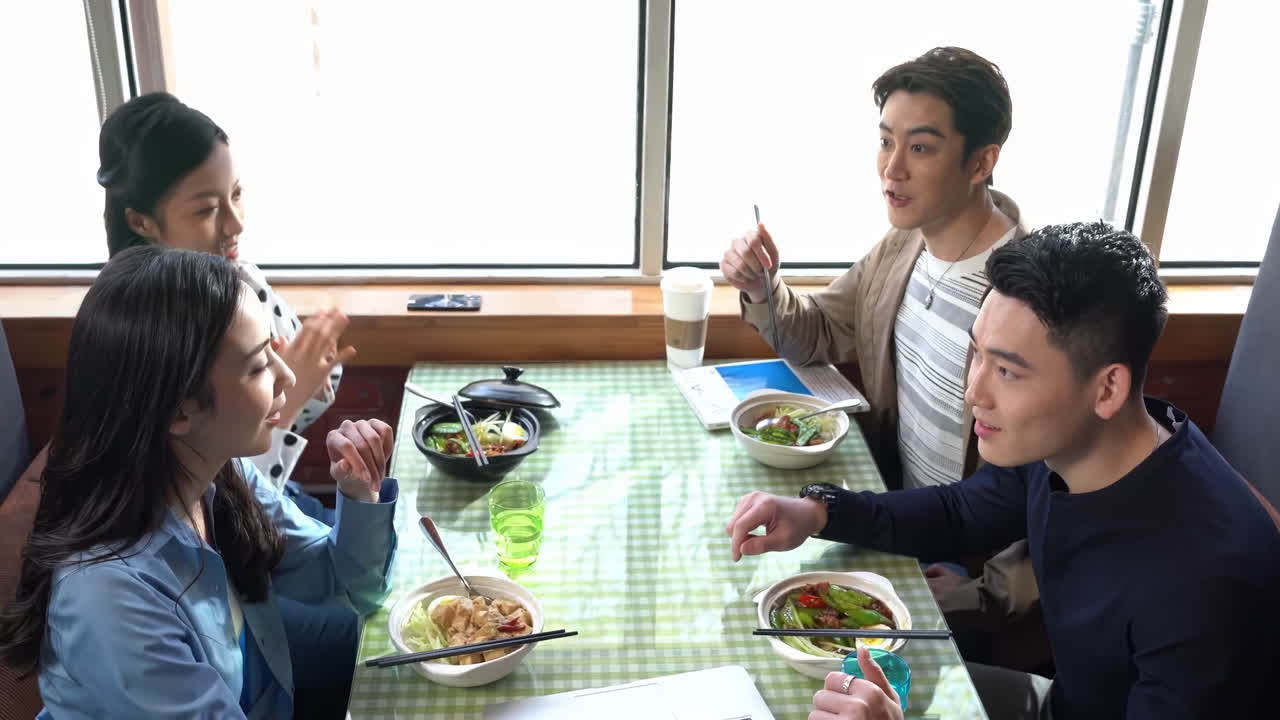 Group of young business people are chatting and enjoy lunch break together in the company building. Open space company canteen area. Concept of business, food, meeting, lunch break