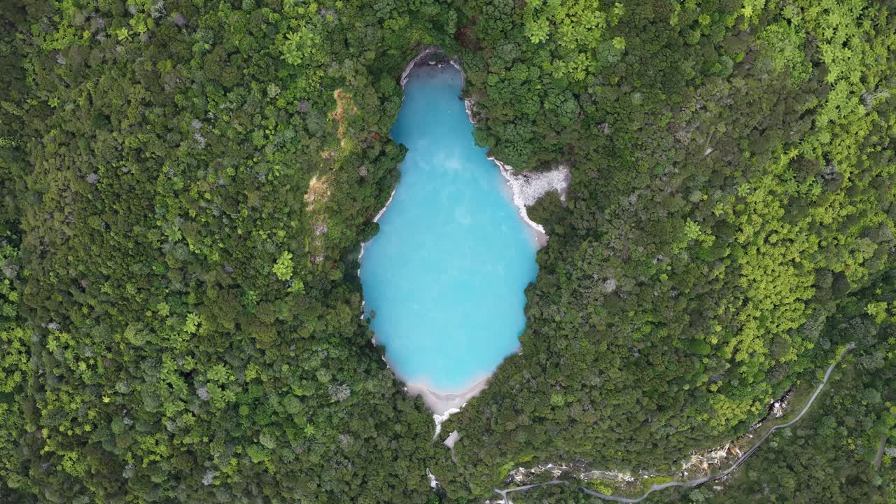 Ripresa drone rotante dall'alto su un lago craterico turchese nella Valle Vulcanica di Waimangu, Nuova Zelanda, immagini di paesaggio geotermico