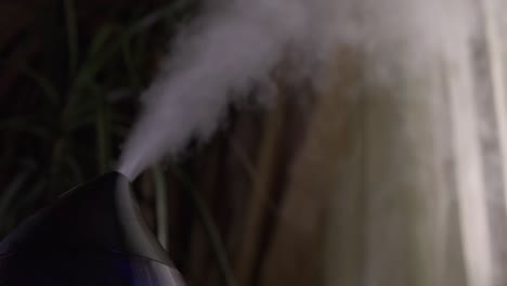 vapor de un humidificador de aire moderno en una habitación oscura. en primer plano, no hay gente.