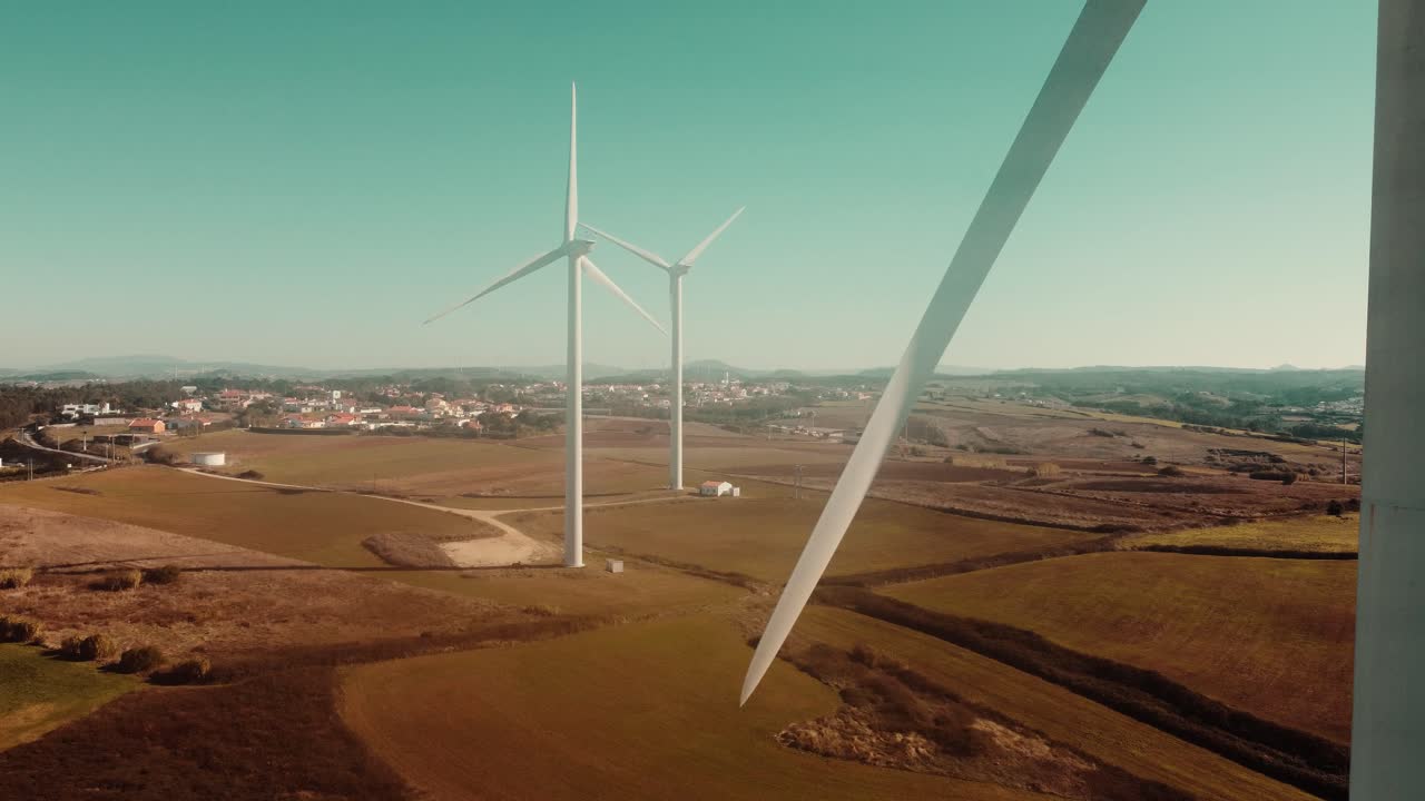 Primo piano della pala di una turbina eolica con un paesaggio verde sullo sfondo, Ericeira, Portogallo