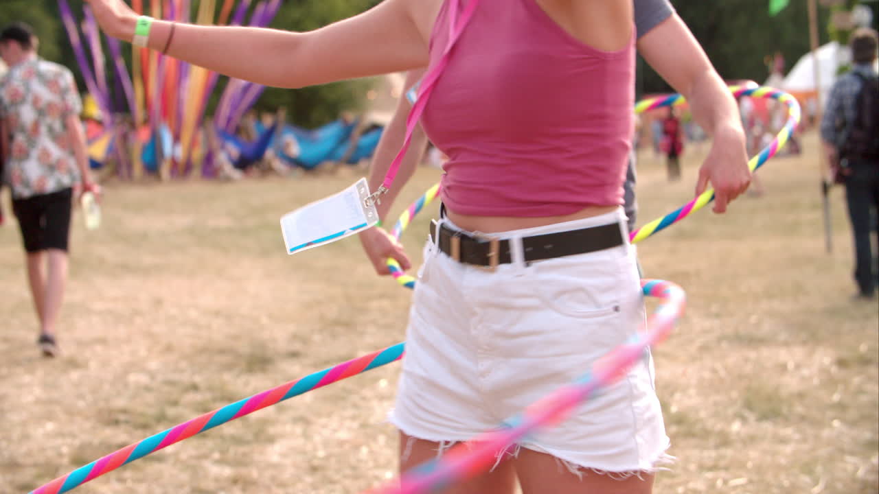 Girl hula-hooping at a music festival, slow motion