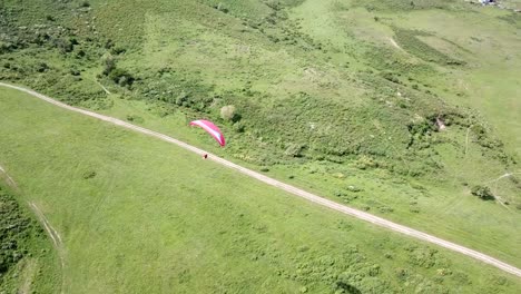 paragliding in the mountains. green fields, hills