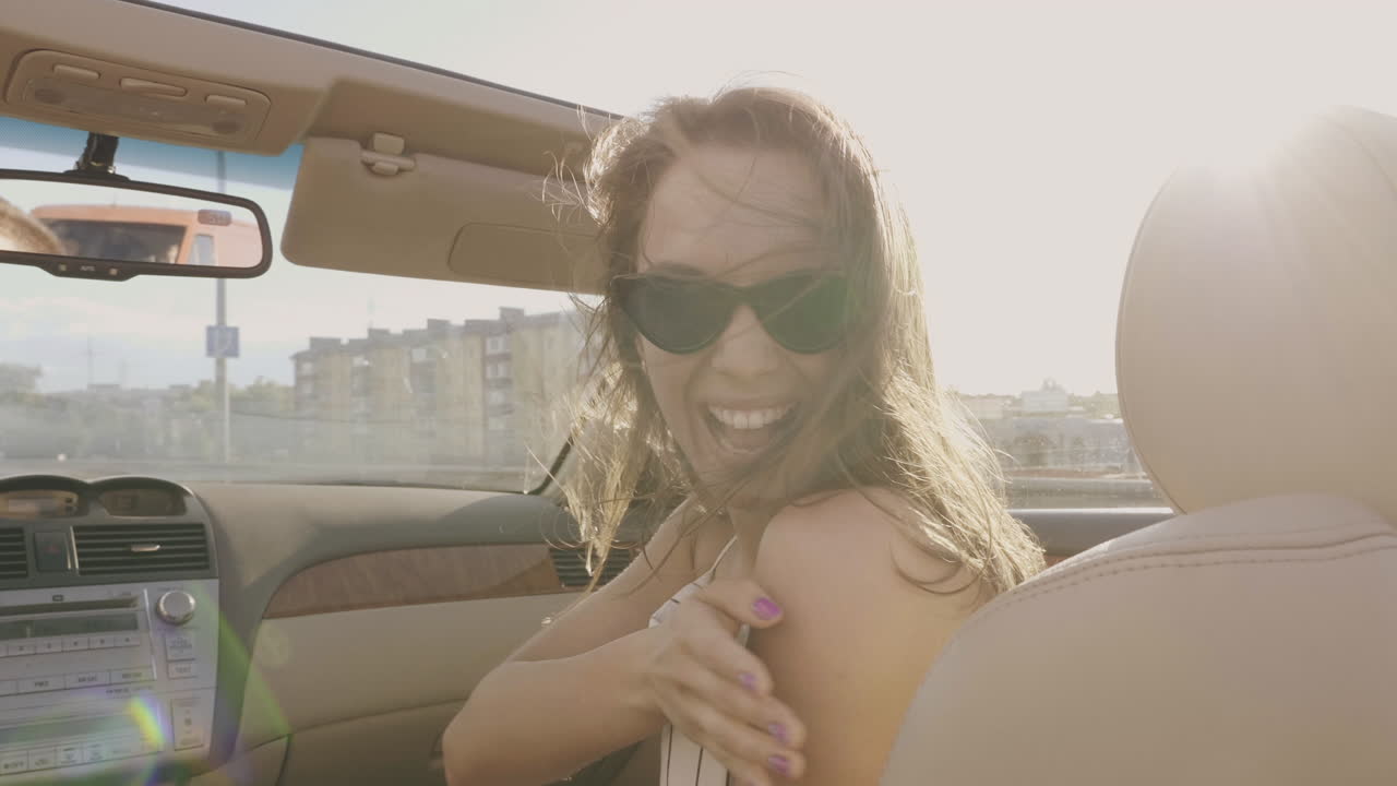 mujer feliz conduciendo en un coche descapotable