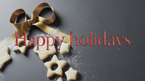feliz vacaciones texto en rojo sobre galletas de navidad y reverencia en fondo gris