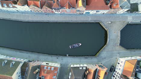 Perpendicular-aerial-drone-view-of-the-river-canals-water-in-Brugge,-Belgium,-with-a-boat