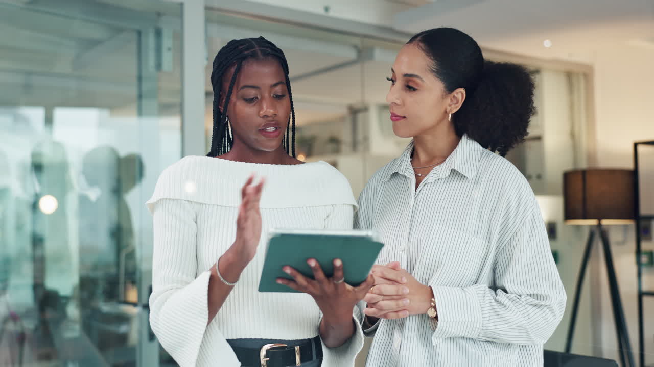 Two Businesswomen Collaborating on a Tablet in an Office