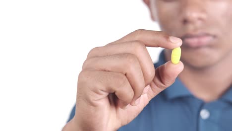 person holding a yellow pill