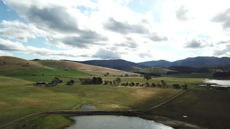 drone pan up over rural dam and hillside in tasmania, australia