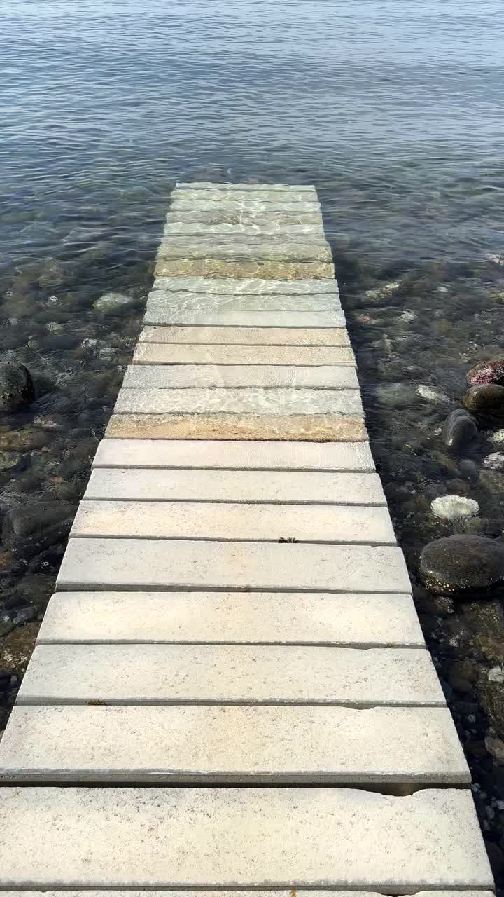 un muelle de madera que se extiende en el agua tranquila del océano
