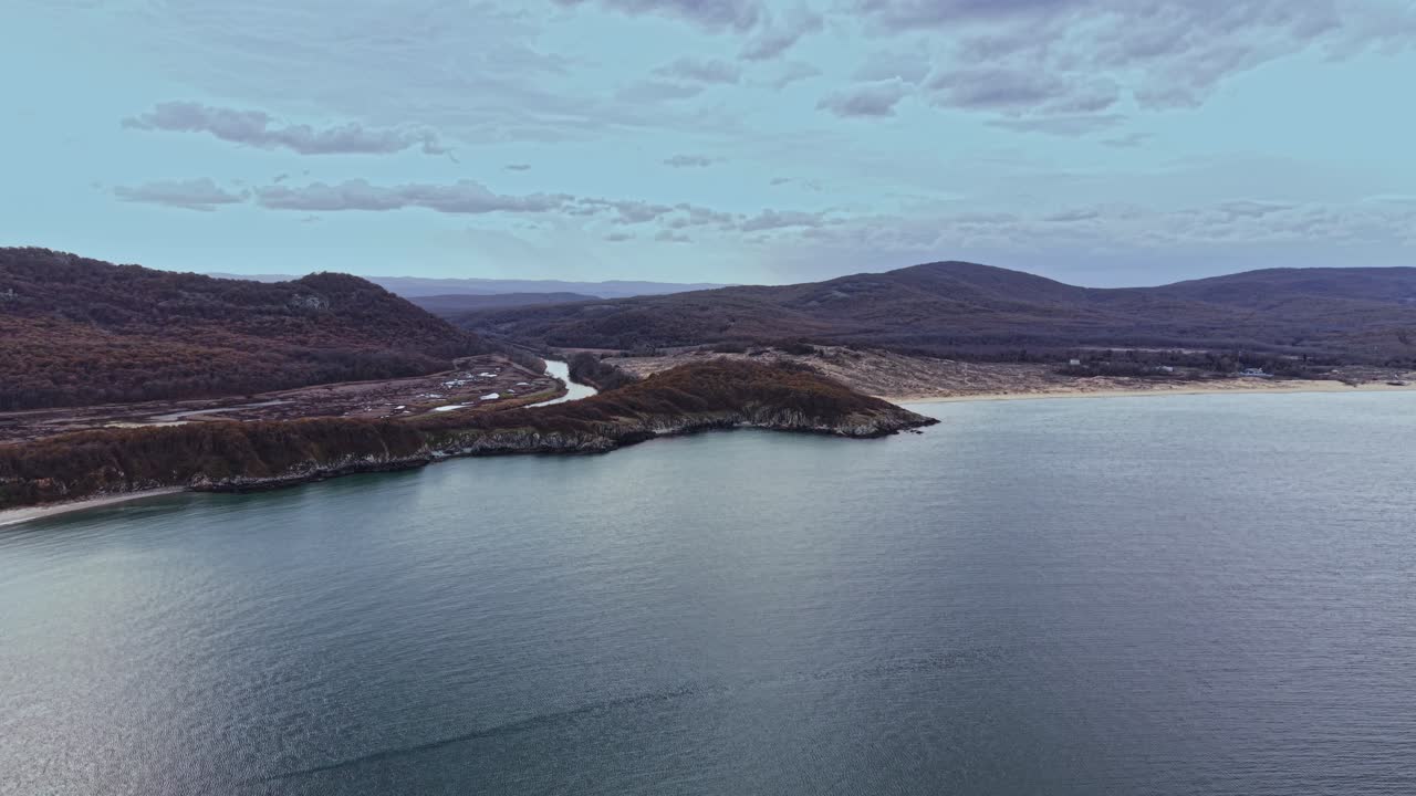 Stunning aerial view of coastal landscape with hills and calm waters