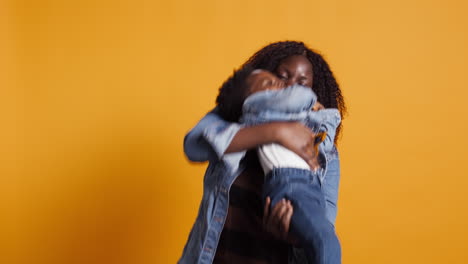 sonriente madre afroamericana llevando a su dulce niño en el estudio