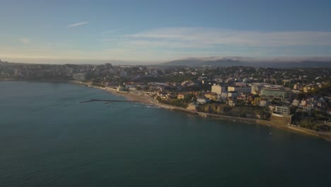 Aerial-view-of-Estoril-and-Forte-da-cruz-castle-at-sunset,-on-a-sunny-evening