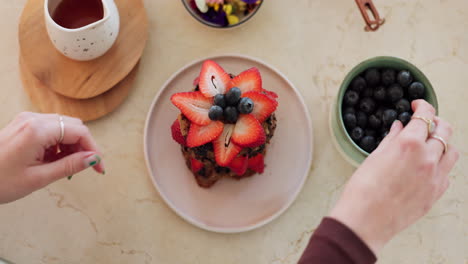manos, postre de fresa y cocina en la mesa
