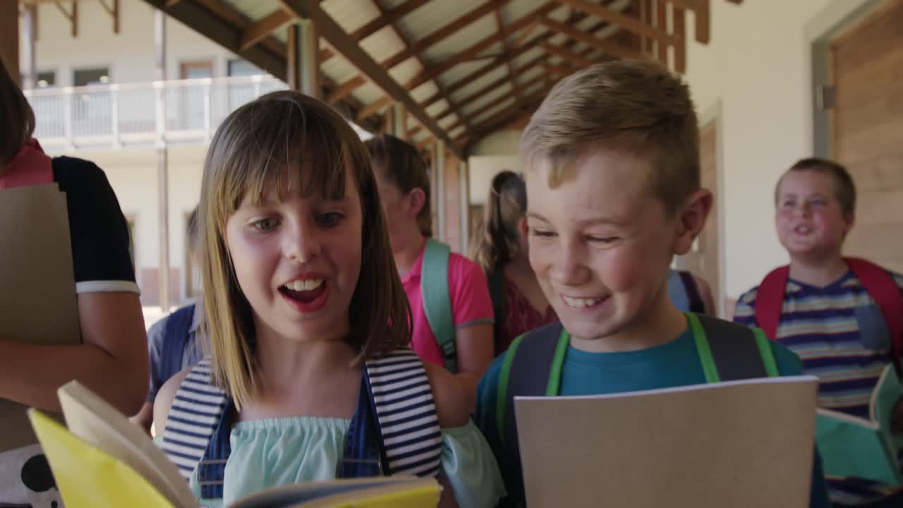 Group of kids with books walking in the school corridor