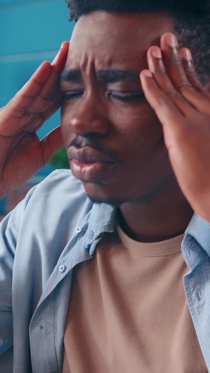 A young man struggles with stress at a cafe while deep in thought