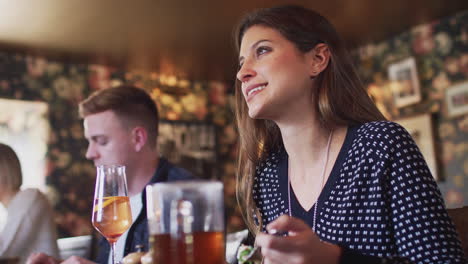 Grupo-De-Personas-Comiendo-En-El-Restaurante-De-Un-Concurrido-Pub-Inglés-Tradicional.