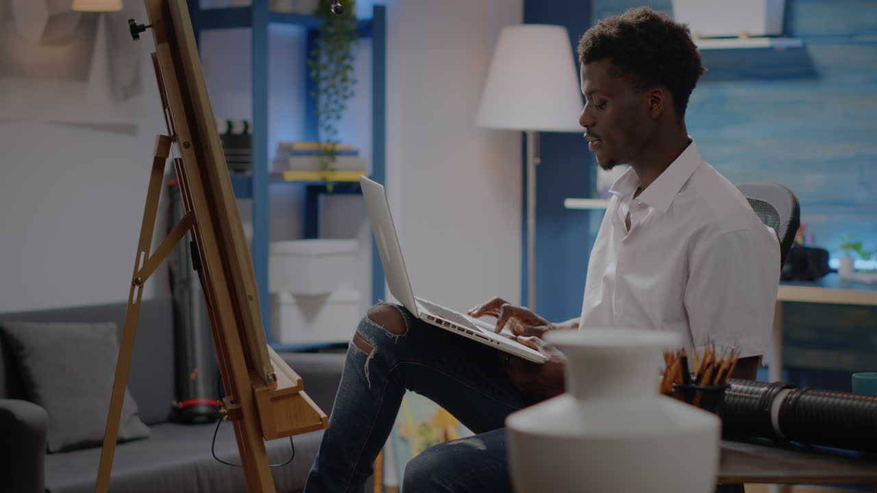 Black young artist using laptop technology for art concept