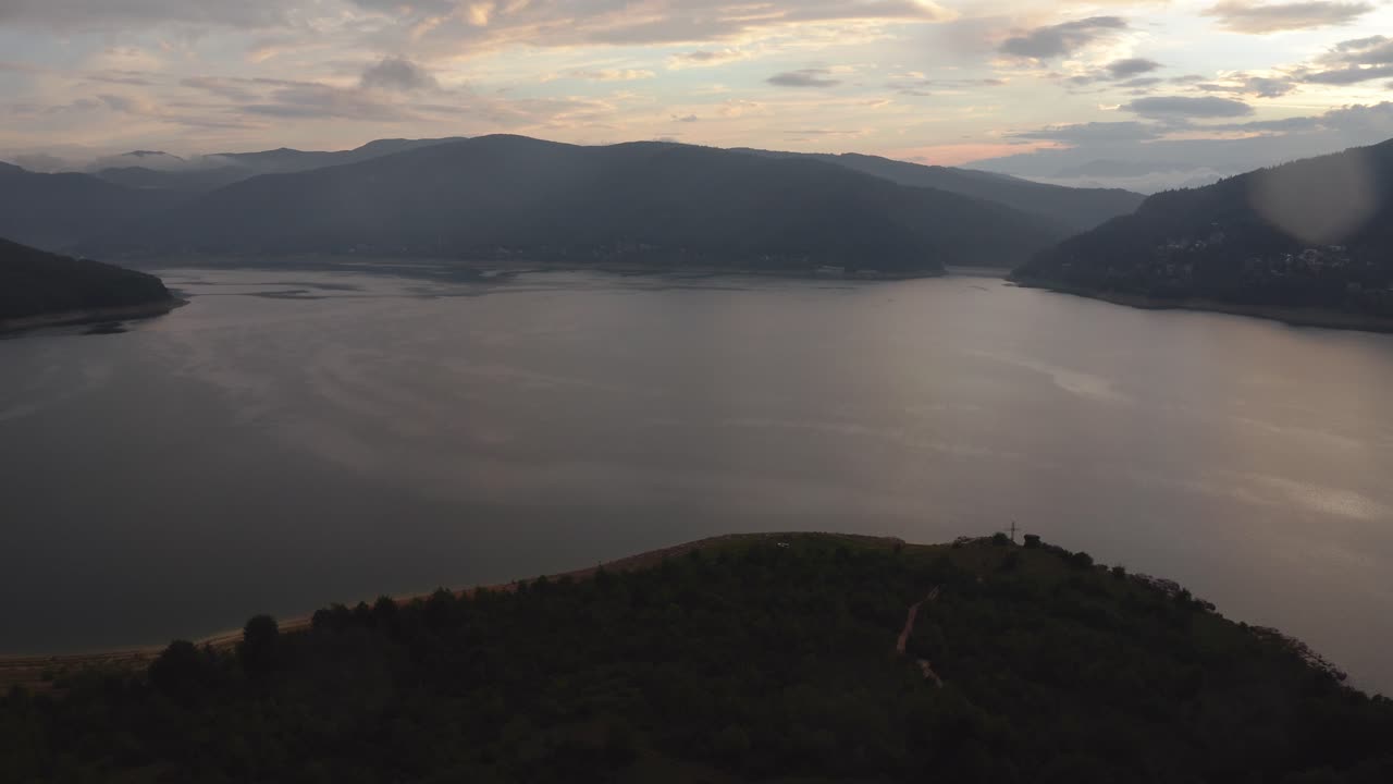 vista de pájaro de un lago tranquilo en el norte de macedonia con una hermosa puesta de sol en el fondo