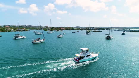 un barco de pesca con cañas en la parte de atrás navega a través de las aguas españolas al mediodía, curacao