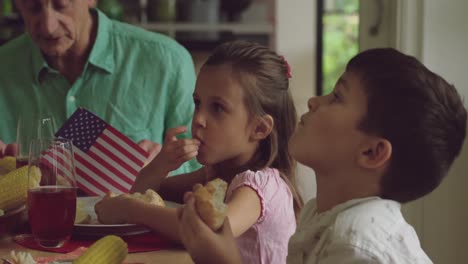 tres generaciones de familia comiendo juntas.