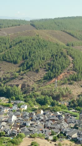 scenic view of a village in a mountainous forested landscape