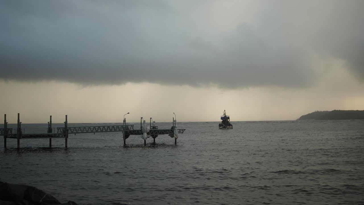 View a bridge and ship from above water under a dramatic cloudy stormy sky