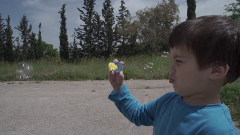 niño juega con un juguete que sopla burbujas a cámara lenta