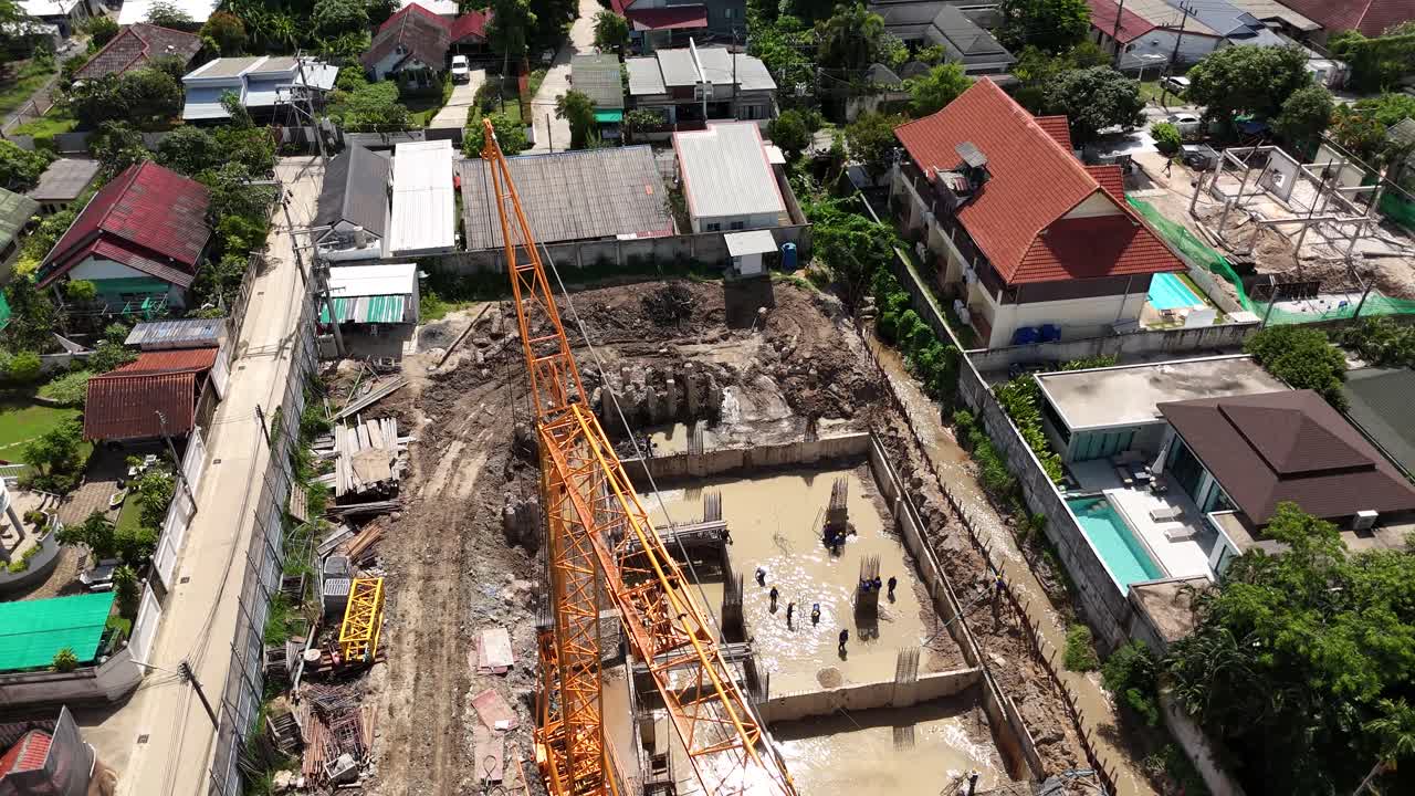 Aerial View of a Residential Construction Site with Crane and Workers