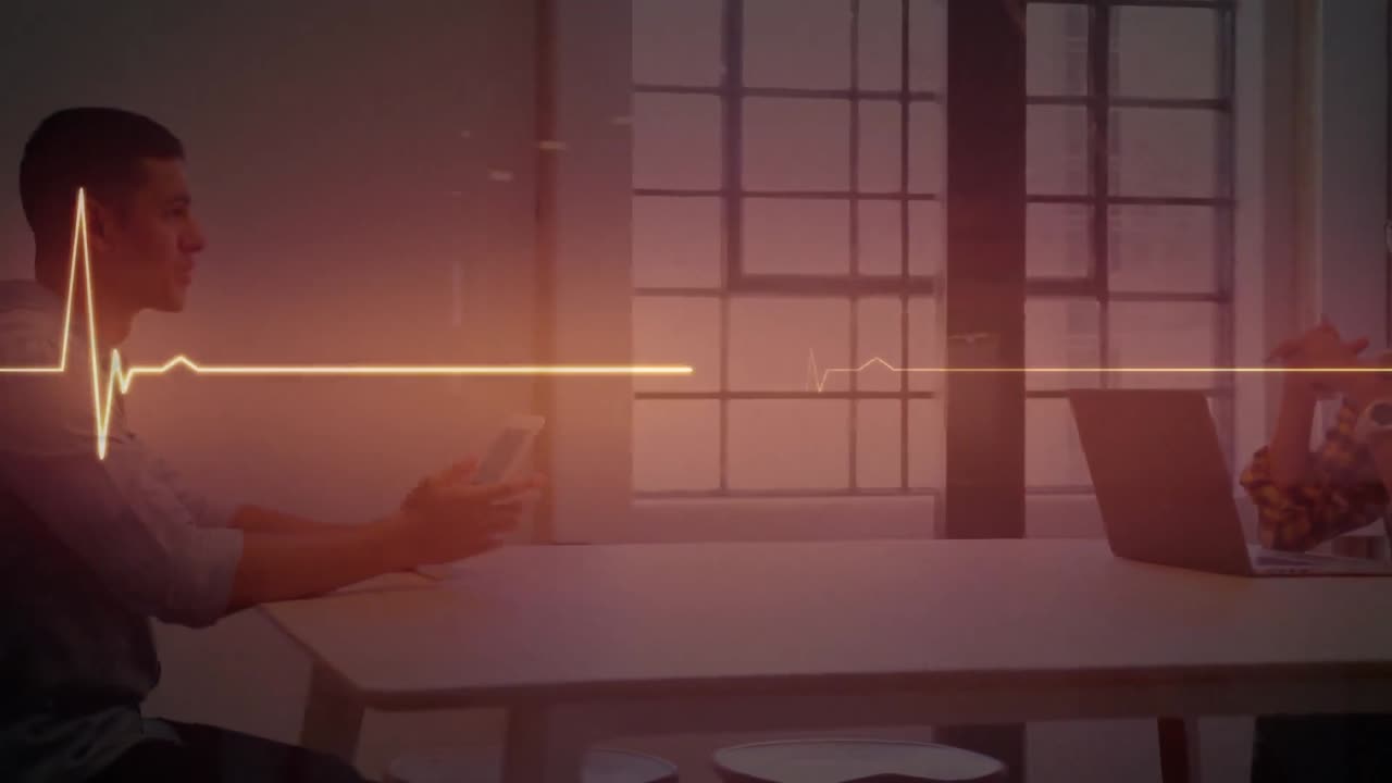 노트북 및 태블릿을 사용하여 회의에서 동료를 통해 반 ⁇ 이는 오렌지색 심박수 모니터의 애니메이션