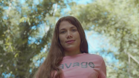 linda chica latina en una camisa rosa con una catedral de bambú en el fondo