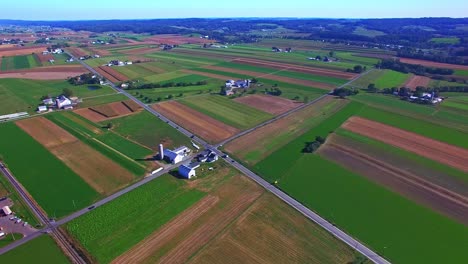 an aerial view of pennsylvania farmlands and businesses with multiple color and shape fields on a sunny day