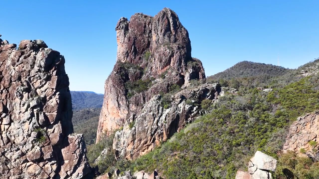 Uma águia-de-cauda-em-cunha voa pela formação rochosa The Breadknife no Parque Nacional Warrumbungle, Austrália.
