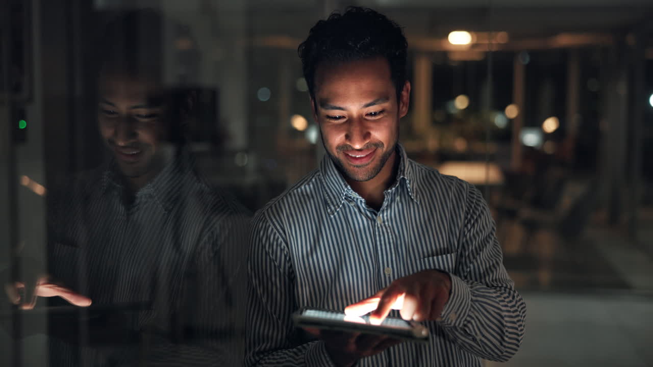 Smiling Man Using Digital Tablet in Modern Office at Night