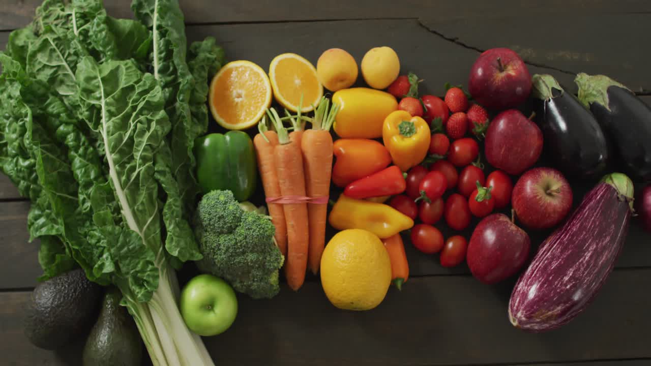 vídeo de frutas y verduras frescas de colores en tablas de madera en el fondo