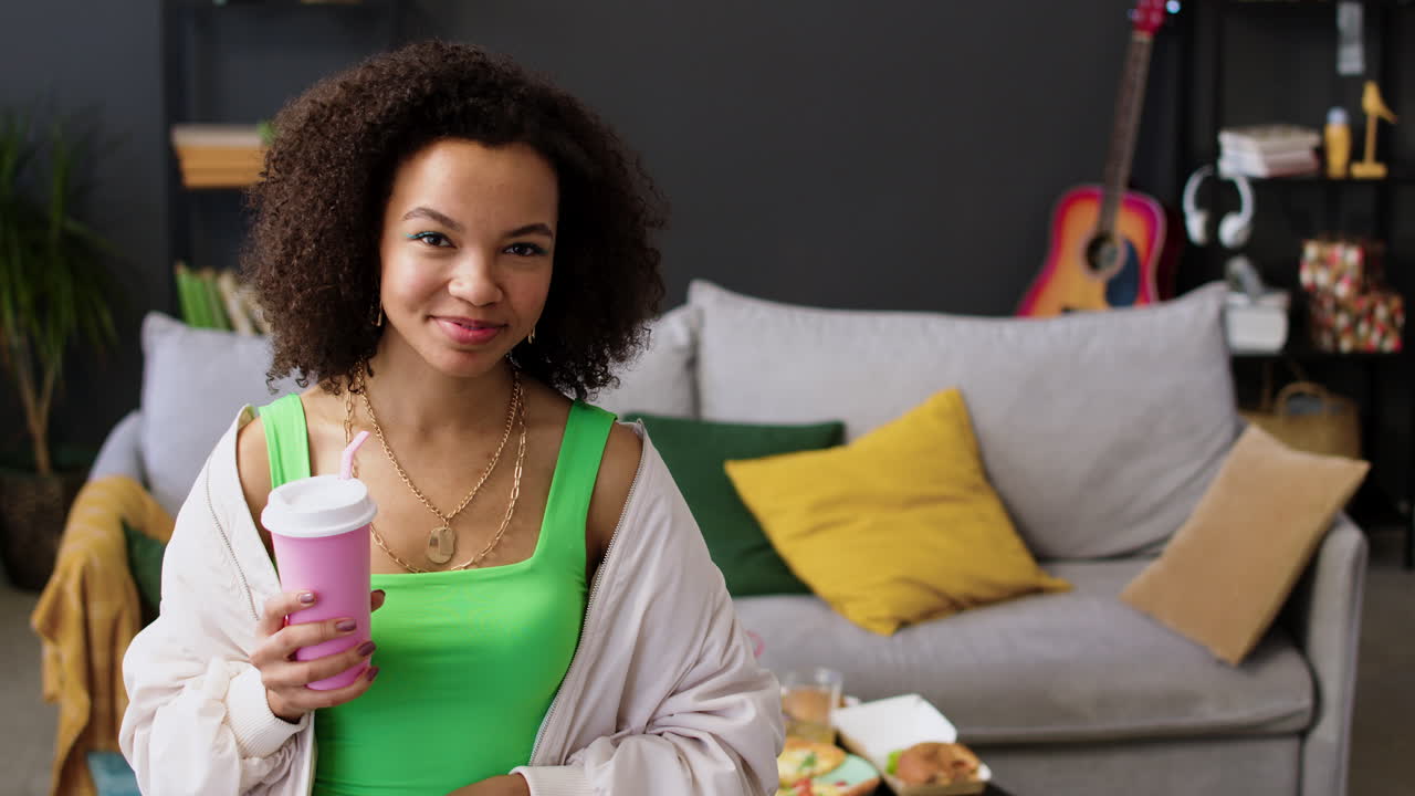 mujer bebiendo refresco en una taza de plástico