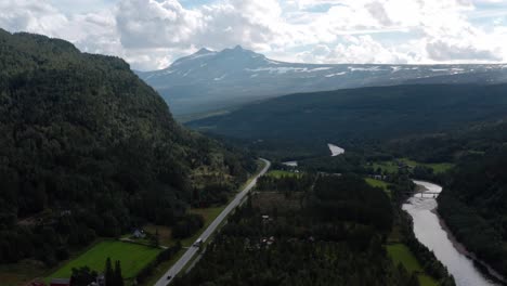 lush green landscape of beautiful mountains and a river in norway drone shot