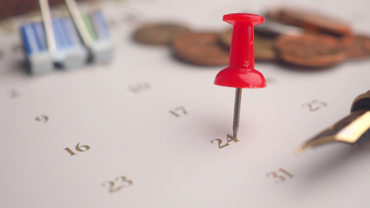 Red Pushpin Marking a Date on a Calendar