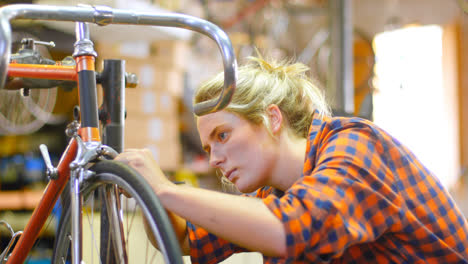 woman repairing bicycle at workshop 4k