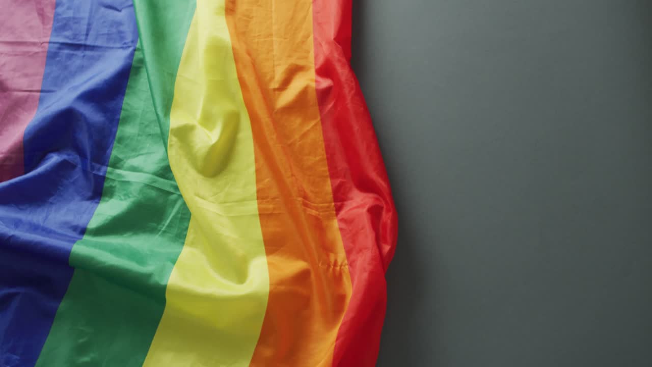 video de una bandera arco iris arrugada sobre un fondo negro