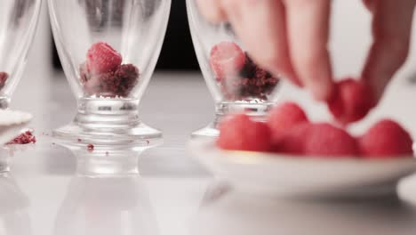 Cocinando-Un-Delicioso-Postre-De-Chocolate-Con-Frambuesa-Agarrando-Con-Los-Dedos-De-Un-Plato-En-Un-Restaurante-Local-Detalle-Plano-Medio