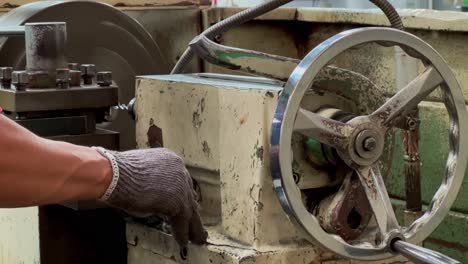 la mano del operador de la máquina está controlando manualmente el movimiento de la máquina girando el control del ajustador