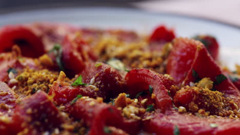 Plate-of-marinated,-flamed-red-peppers,-extreme-close-up-pan