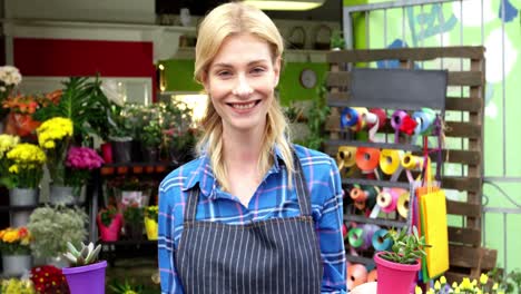 Female-florist-holding-plant-pot-in-flower-shop