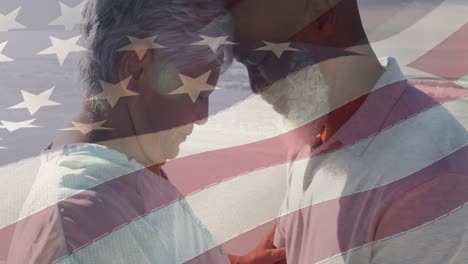 animation of flag of usa over happy senior biracial couple in love embracing on beach