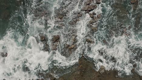 Top-View-Of-Foamy-Waves-Hit-On-Rocky-Outcrops-On-The-Shore-In-Guanacaste-Beach,-Costa-Rica