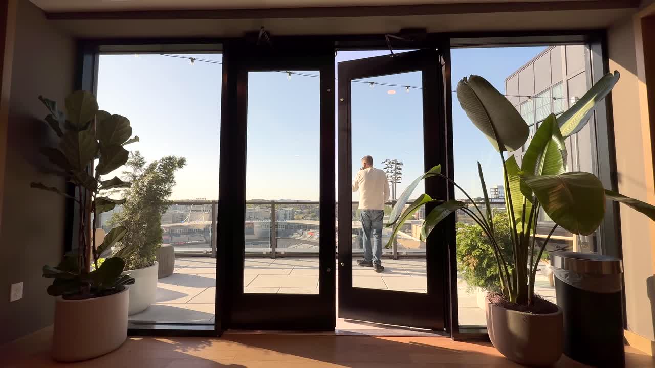 Man walks out of a business conference room to take an incoming call on his smartphone