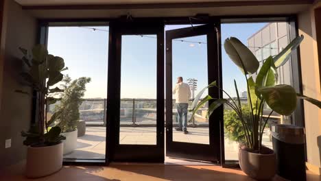 man walks out of a business conference room to take an incoming call on his smartphone