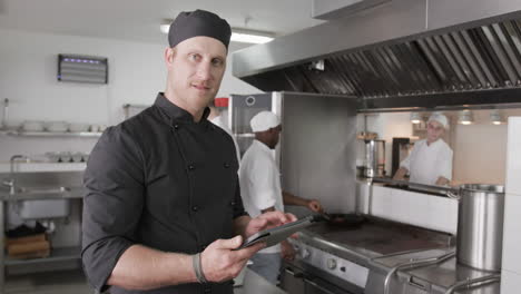 Caucasian-male-chef-using-tablet-in-kitchen,-slow-motion