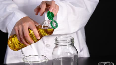 vertiendo aceite en una jarra para un experimento científico